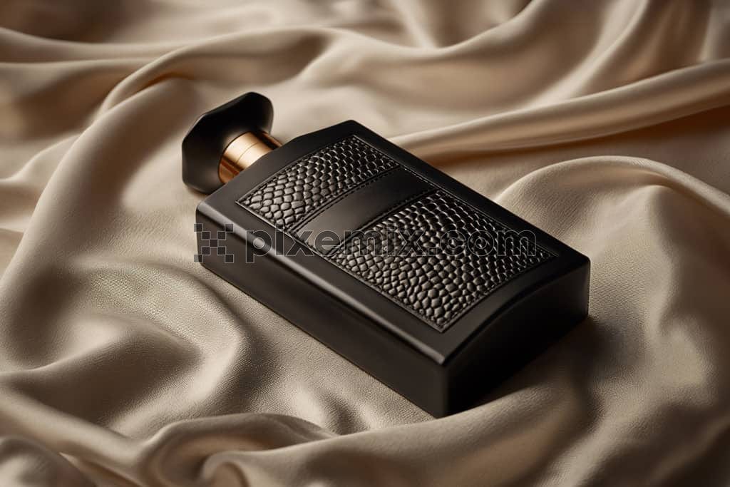 An image of a perfume black bottle on a satin fabric.