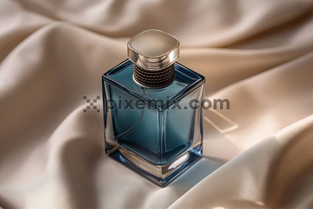 An image of a  perfume blue bottle on a satin fabric.