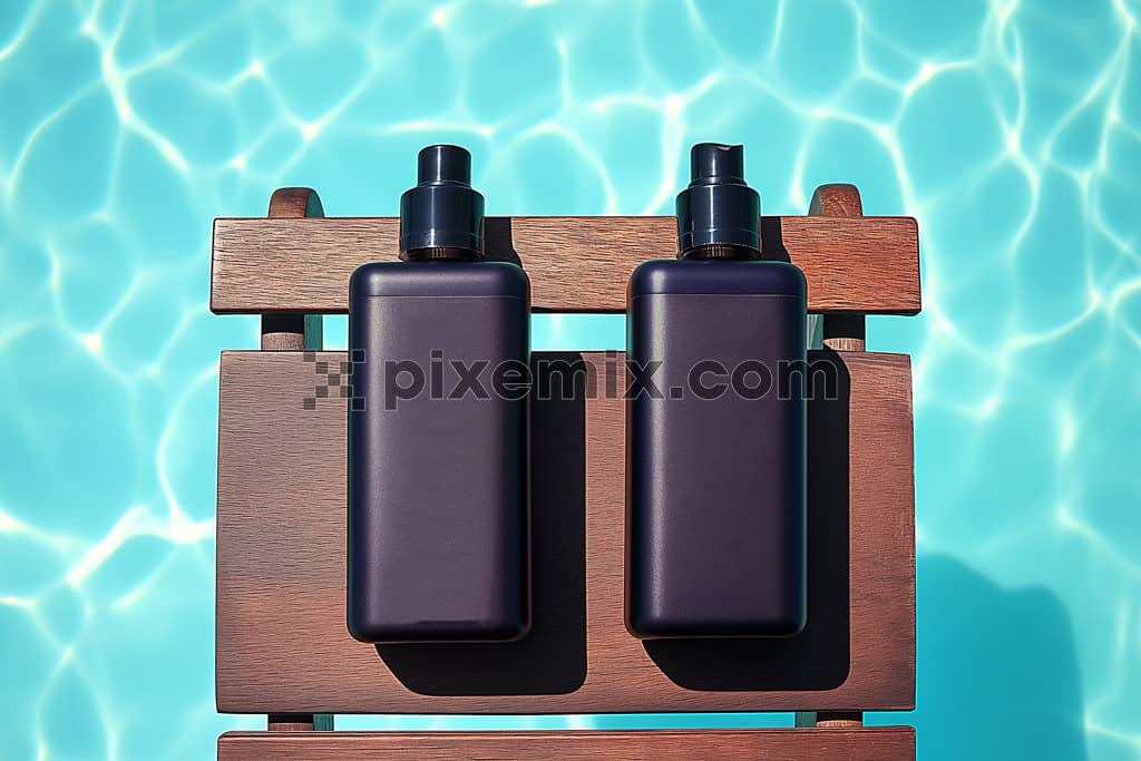 Image of two unlabeled black haircare bottles on a wooden rack by a swimming pool.