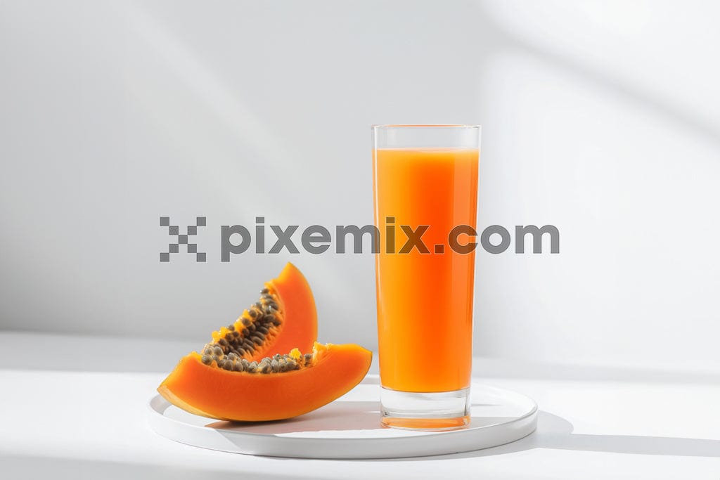 Glass of pappya juice and slices of pappya fruit on white background image.