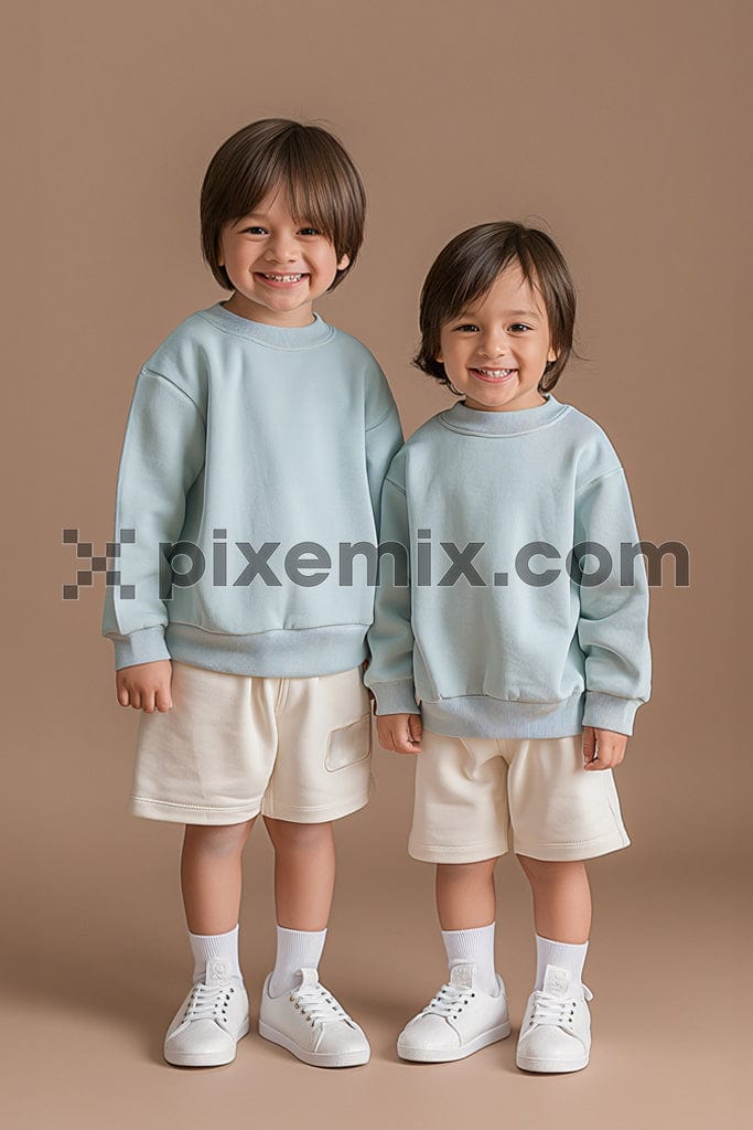Two kids standing on beige background image.