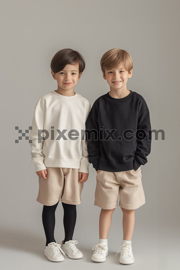 Two kids boys standing smiling on a grey background image.