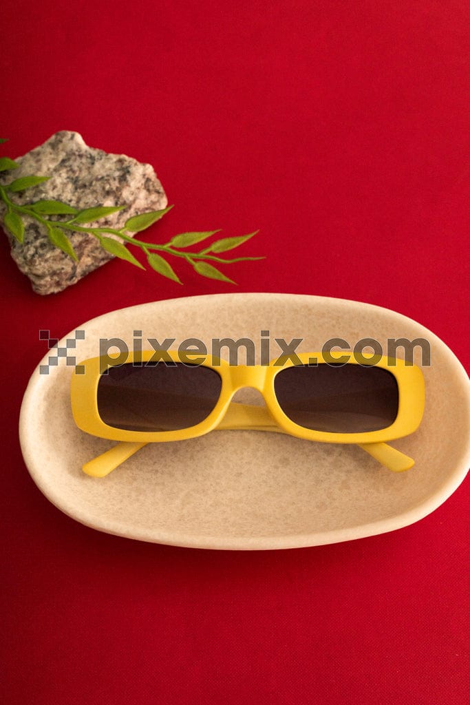 Stylish yellow sunglasses with on red background image.