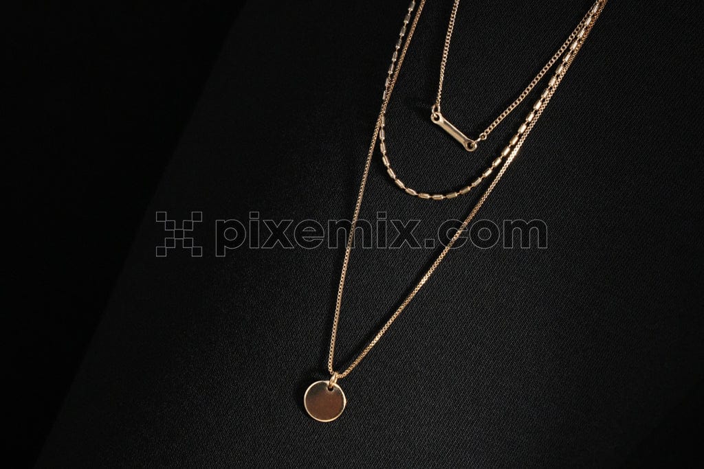 A gold necklace with black background image. 
