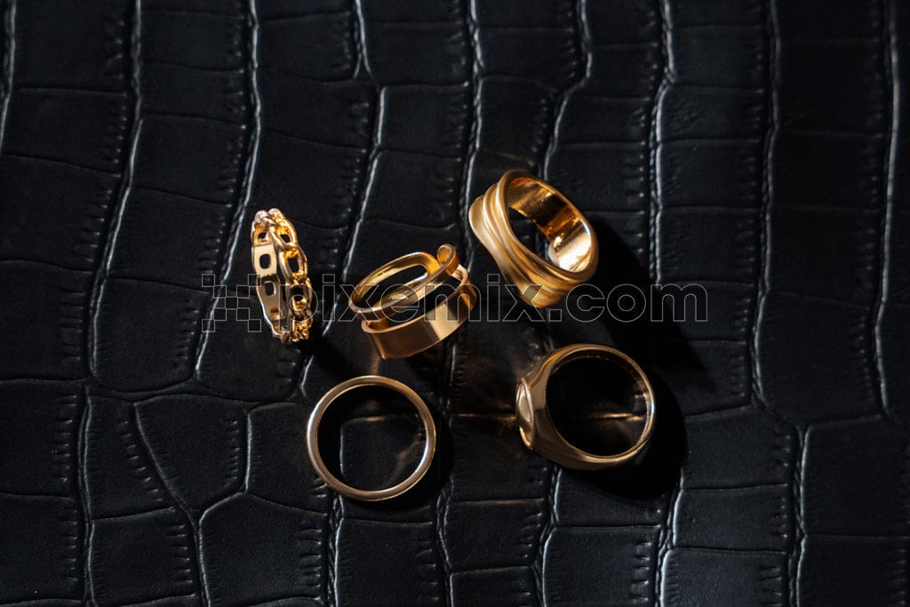 Gold earrings on leather background image.