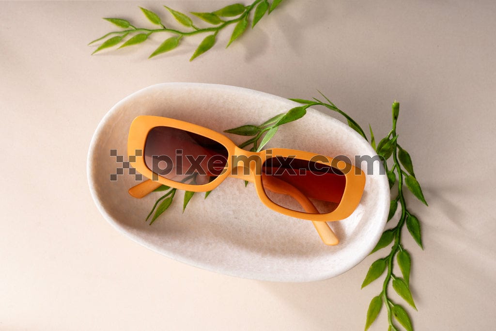 Stylish yellow sunglasses with on beige background image.