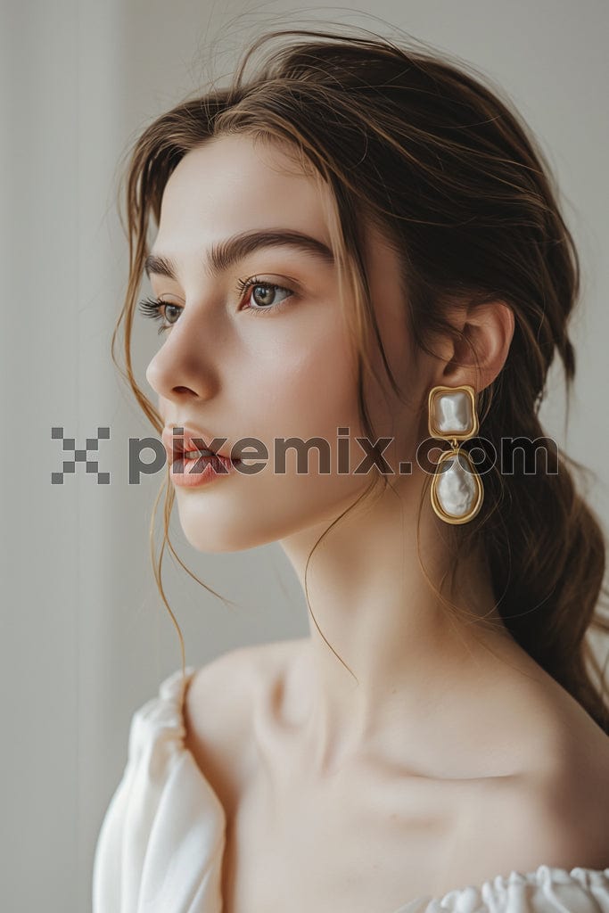 Close up portrait of young beautiful female model presenting golden and silver earrings image.