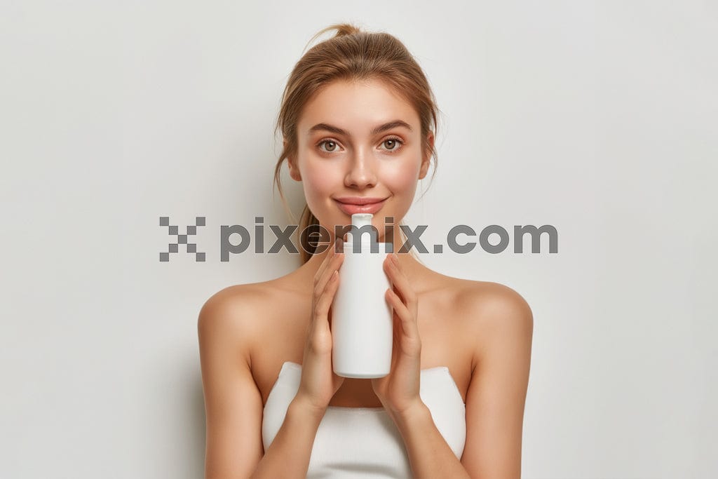 Young blonde girl in the studio with cosmetics bottles on a white background image.