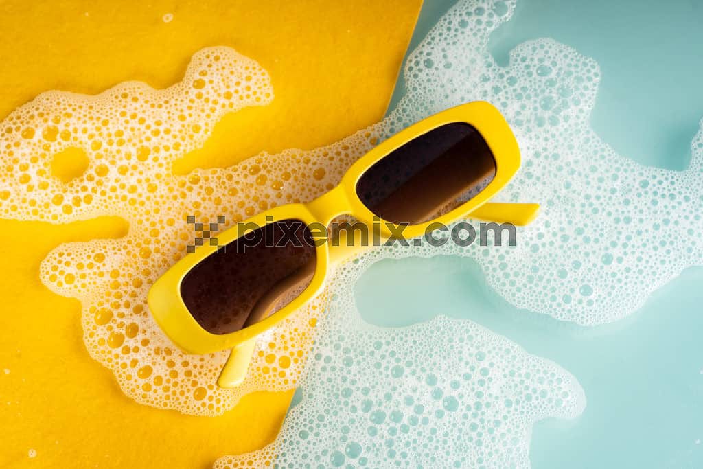 Top view of trendy yellow sunglasses on yellow and blue background image.