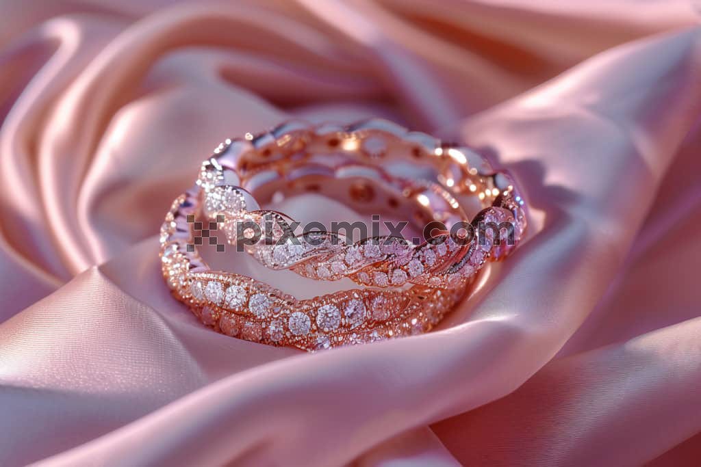Close up of diamond bangles with pink silk image.