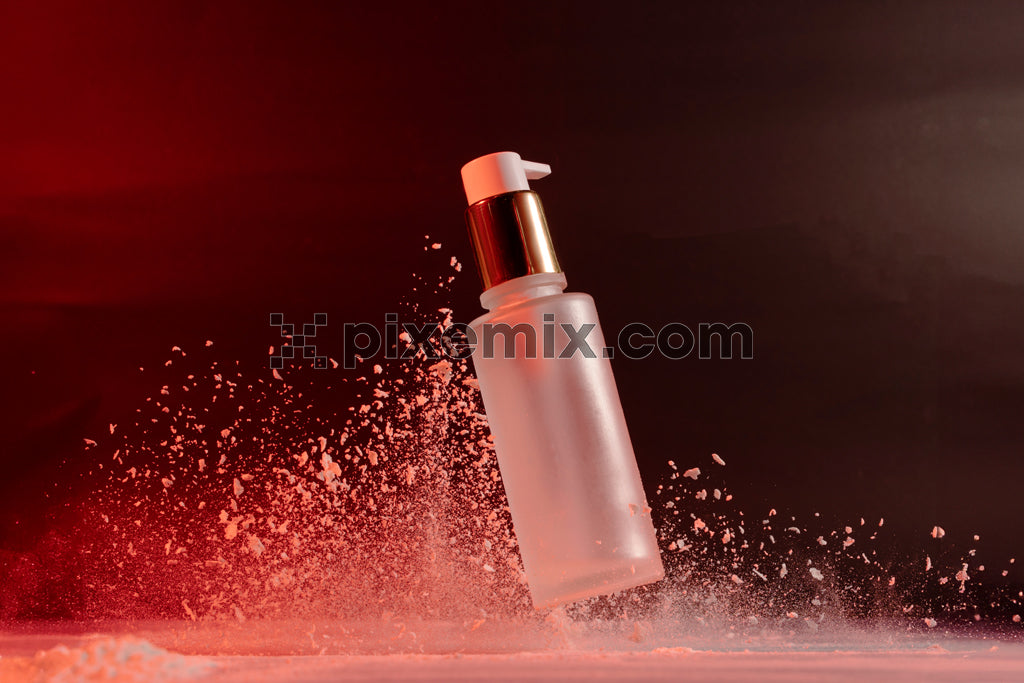 Frosted glass skincare bottle with dispenser captured mid-splash against dramatic red and black background stock image.
