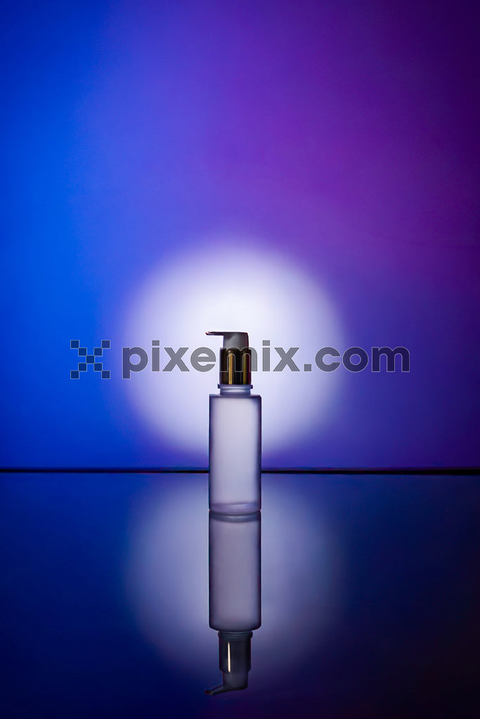 Minimalist cosmetic pump bottle with vibrant purple and blue lighting, creating an elegant product reflection stock image.