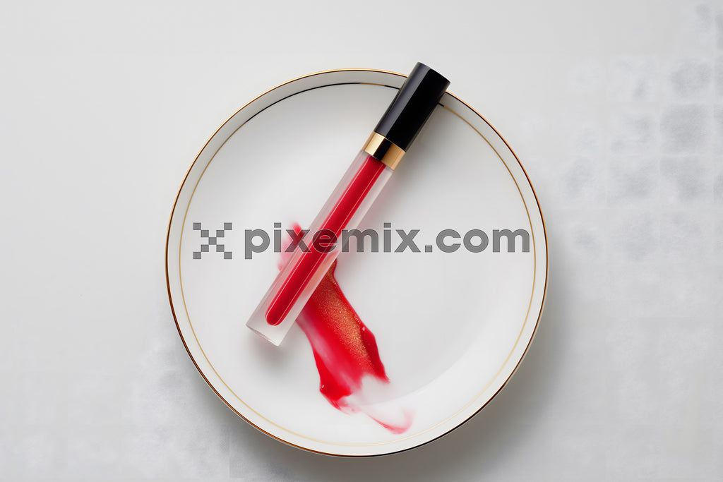 Red lip gloss tube with artistic spill on elegant plate, minimalist beauty product flat lay stock image.