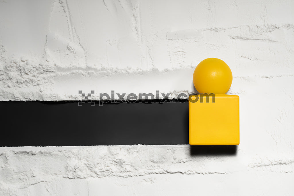 Minimalist composition with yellow cube and sphere on monochrome textured background.