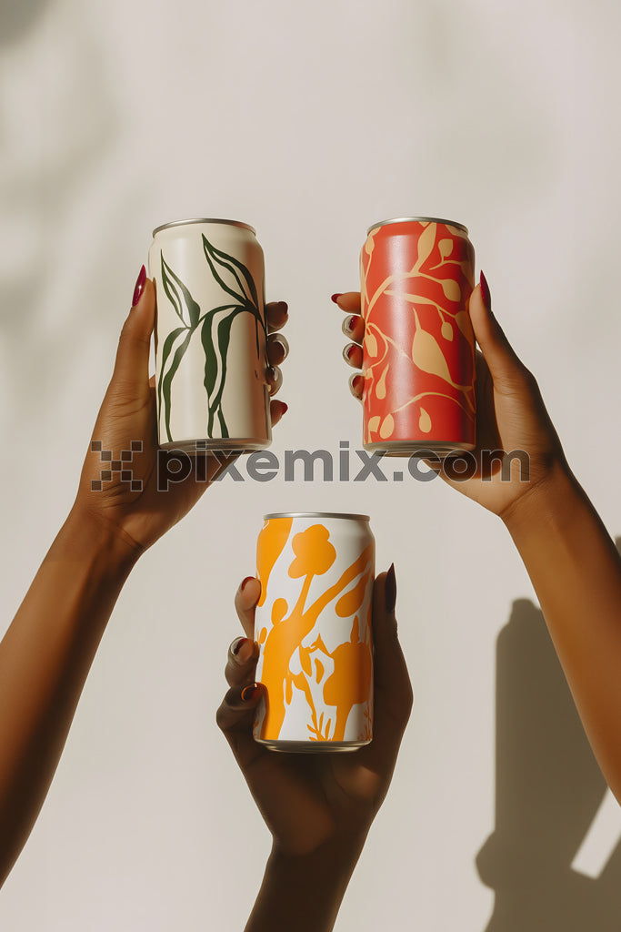Colorful canned beverages held up by diverse hands in minimal light with artistic botanical design.