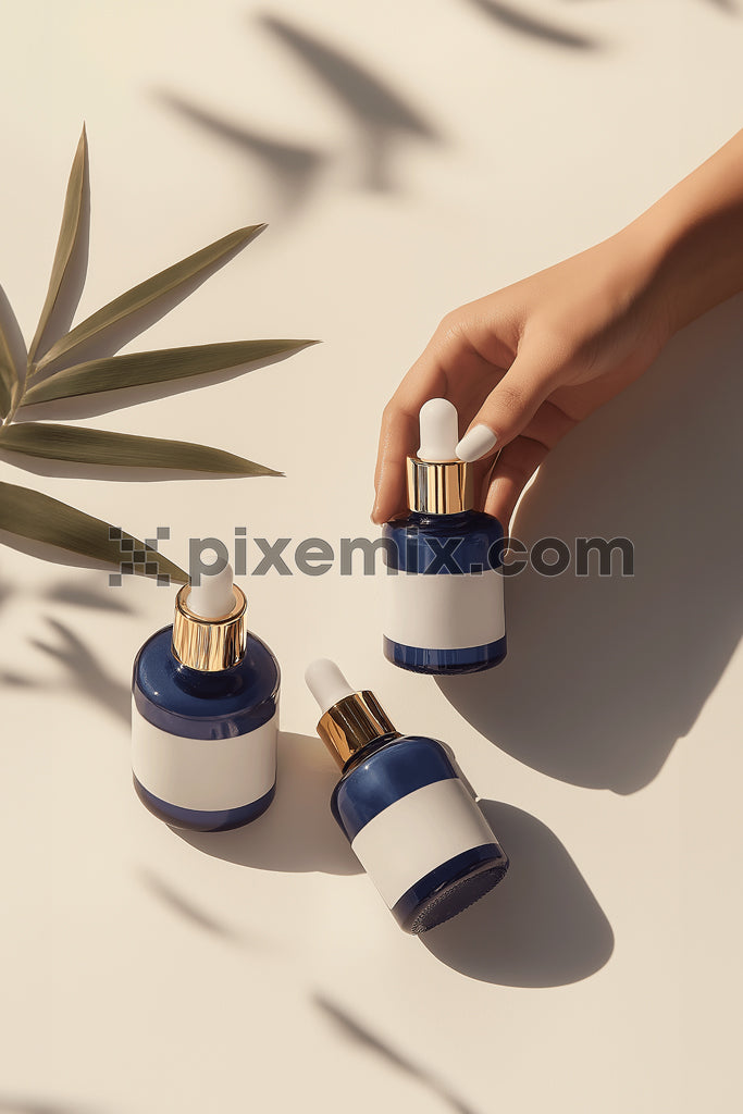 Elegant hand holding blue serum dropper bottle with gold cap on neutral background.