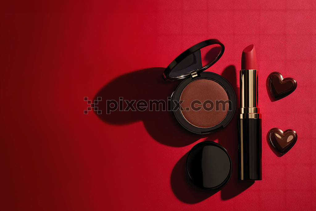 Luxury red lipstick and bronzer with heart-shaped chocolates on red background.
