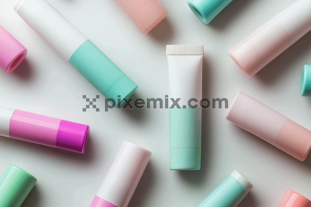 Flat lay of pastel-colored cosmetic tubes and containers on clean white background.