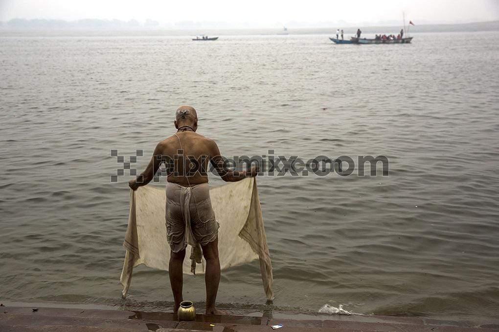 Poojari bathing at banks of ganga ghat image