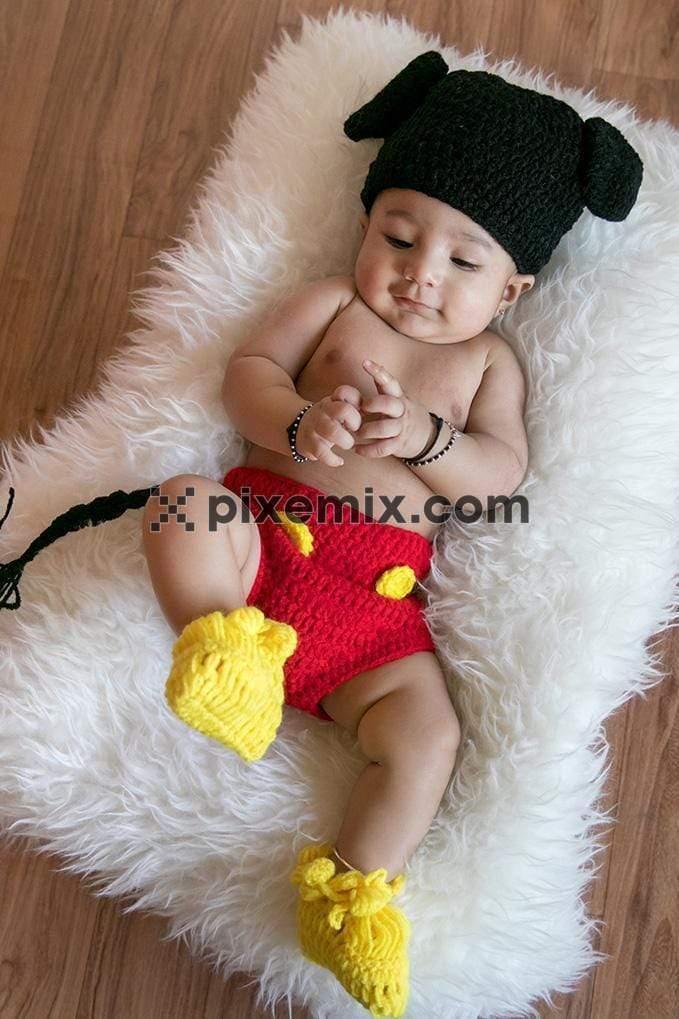 Cute baby on a fluffy pillow with woolen outfit image