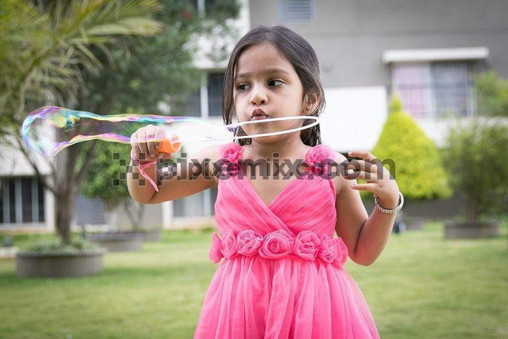 Portrait little cute girl blows soap bubbles image