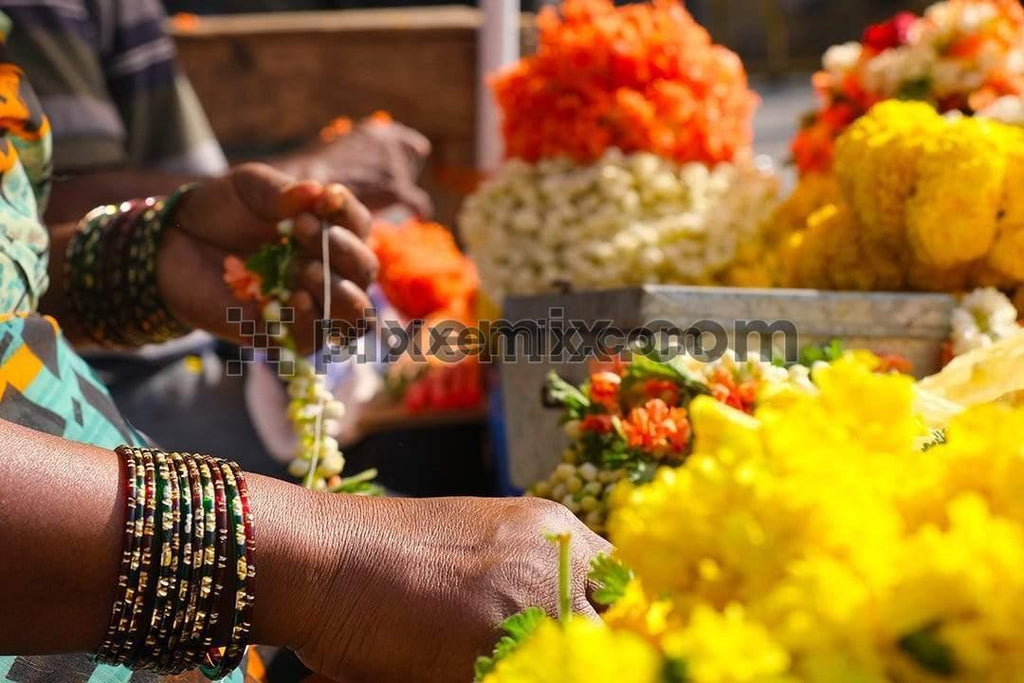 Image of women flower vender making garland's