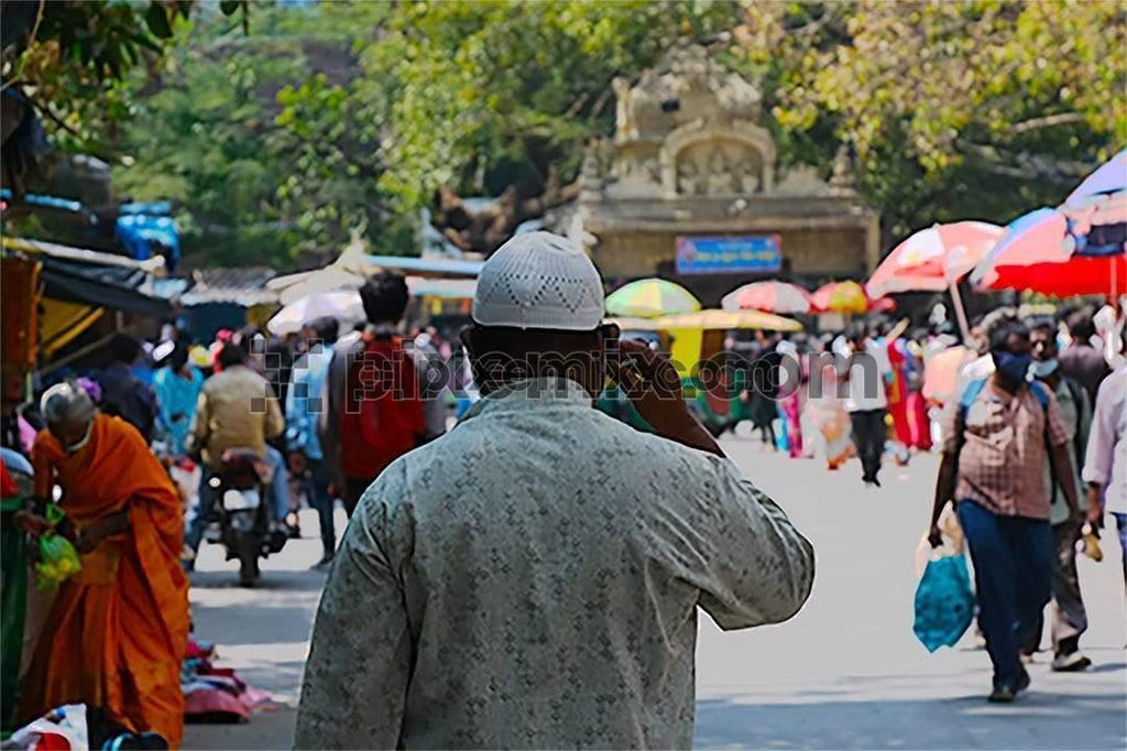 Picture of indian man wearing topi walking in market streets