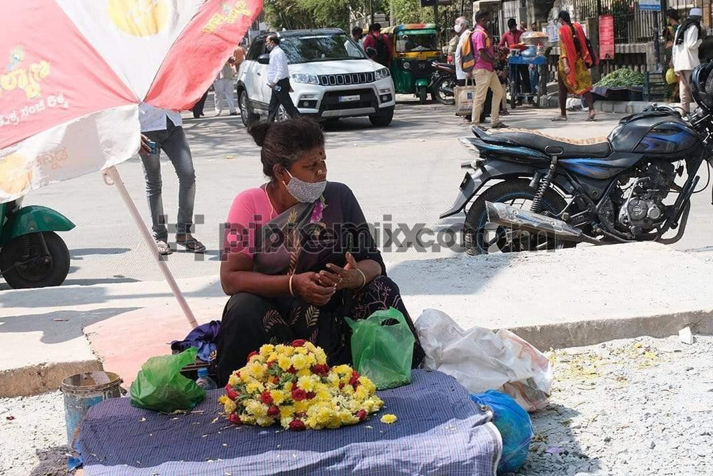 Indian women selling flowers on the side path of street