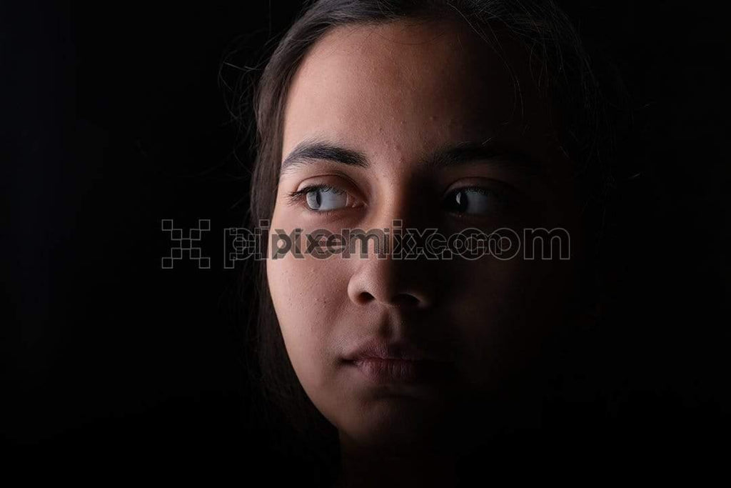 Portrait of indian Young female fashion model with balck background/ women with minimal make-up with shadow on face